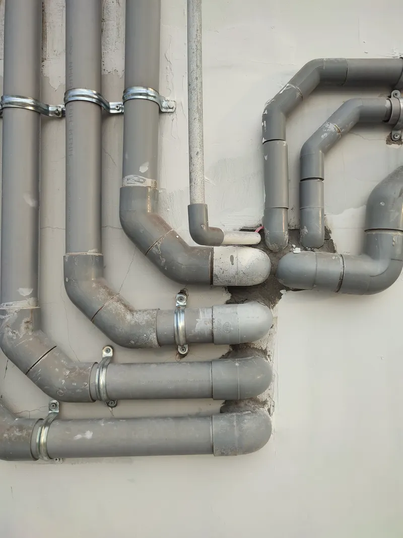 Canalisations d’évacuation en PVC avec raccords et coudes fixés au mur